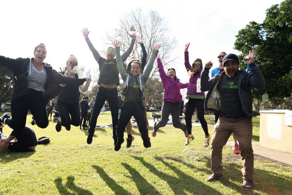 The Mood Active team jumping up in the air with their arms stretched out.